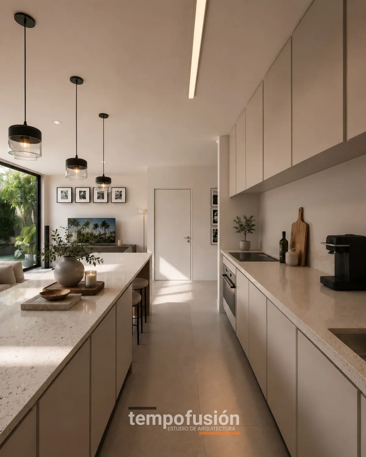 Cocina lineal blanca con isla, lámparas colgantes y ventanal al fondo