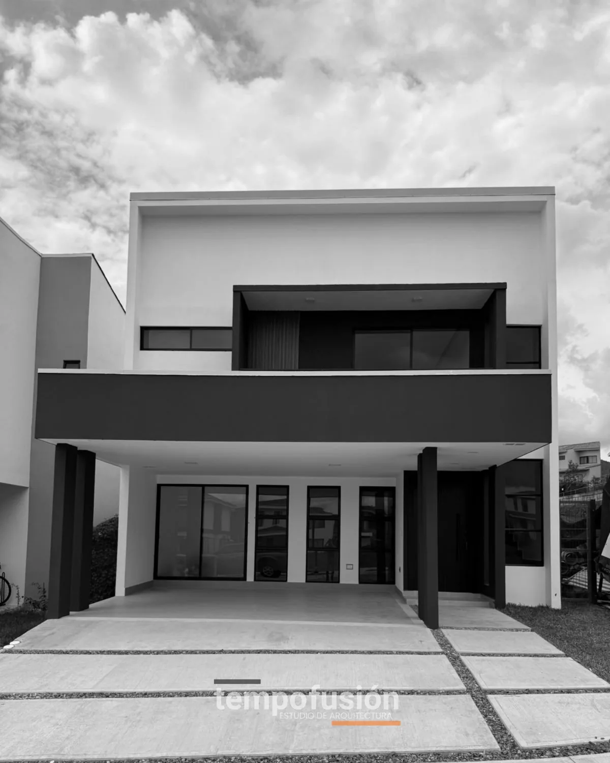 Fachada de dos plantas ya terminada, en blanco y negro