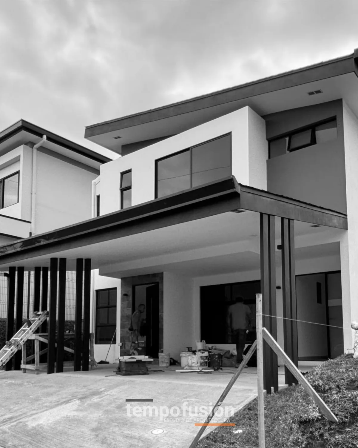 Vivienda en obra con la estructura metálica del techo montada, en blanco y negro