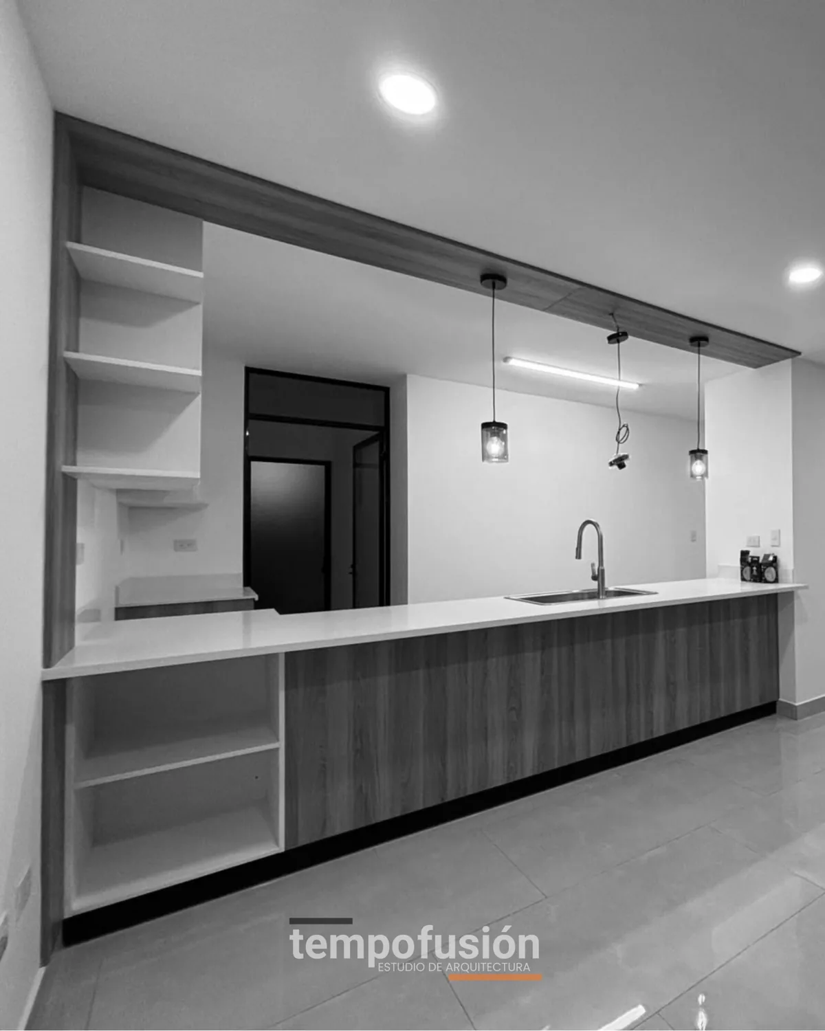 Cocina terminada con isla, repisas abiertas y lámparas colgantes, en blanco y negro