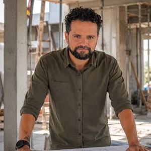 Retrato de Javier Chinchilla con planos en una obra en construcción