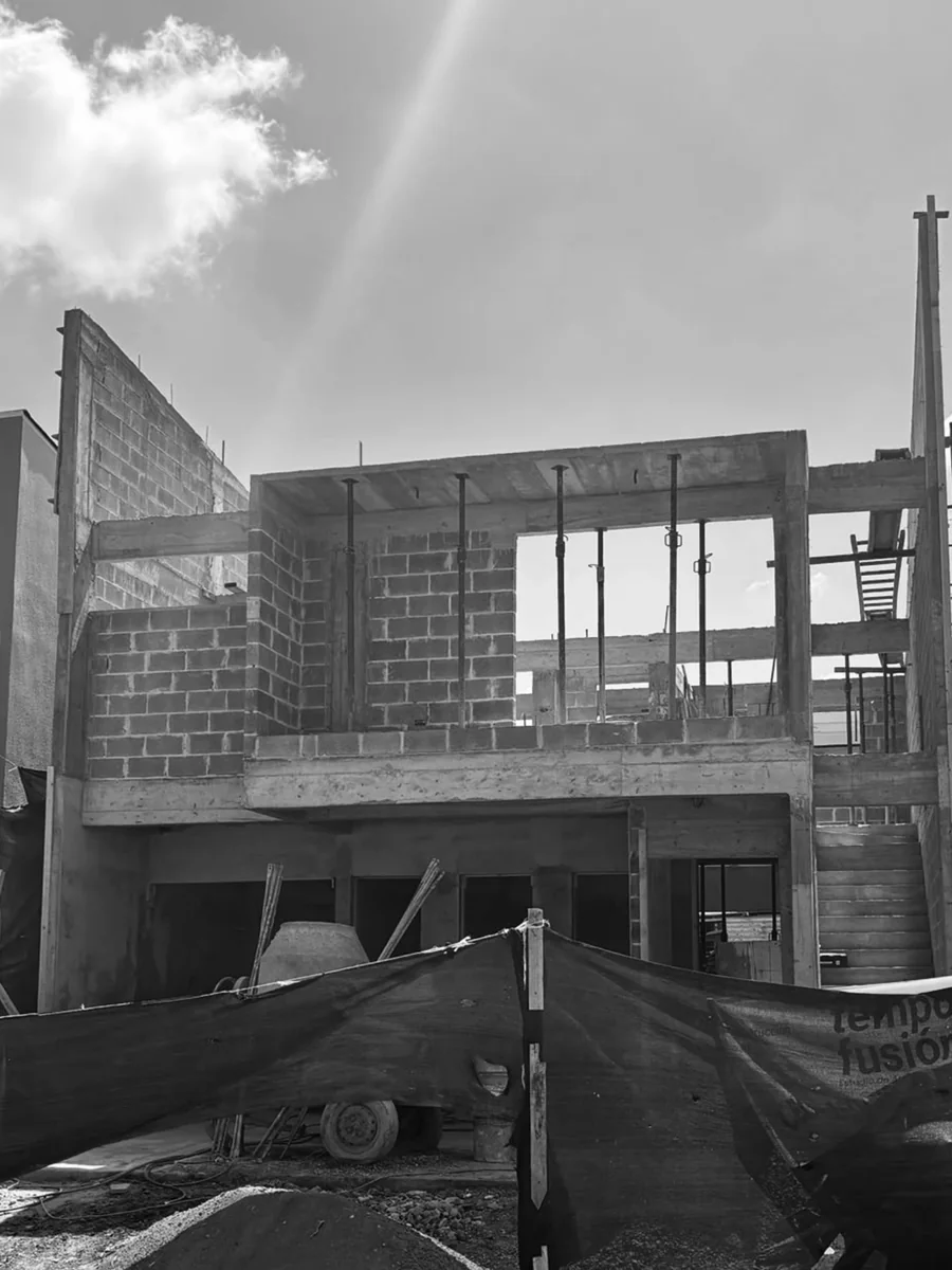 Estructura de vivienda en construcción con bloques y columnas, en blanco y negro